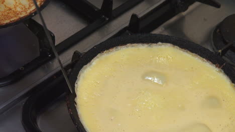 slomo: toma de un cocinero haciendo panqueques en una estufa