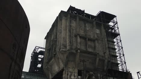 old, decaying, and abandoned industrial building under an overcast sky, creating a stark and desolate scene