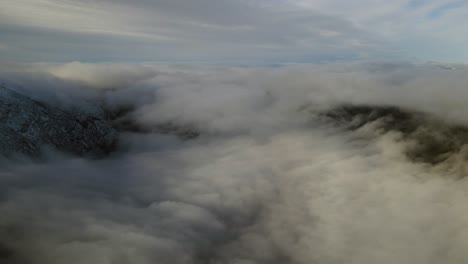 flying over valley covered by clouds