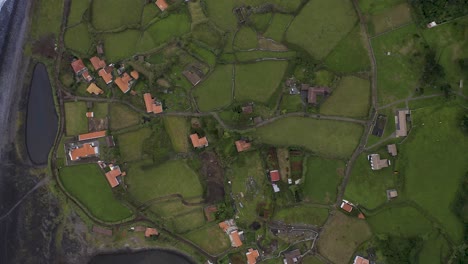 top-down-panorama-view-of-a-coastal-village-lush-green-landscape,-Fajã-de-Santo-Cristo,-São-Jorge-island,-the-Azores,-Portugal