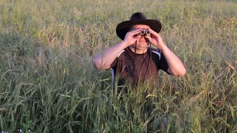 young traveler man holding binoculars on the mountains young traveler man holding binoculars in the field