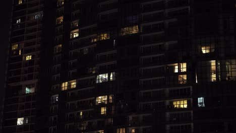 hermosas ventanas de rascacielos vista de modernos edificios residenciales de gran altura, personas que se mueven dentro de apartamentos. vista aérea de abajo