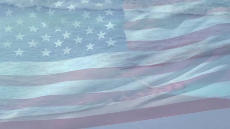 Digital-composition-of-waving-us-flag-against-aerial-view-of-the-beach