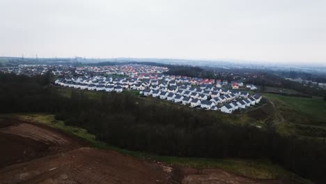 Toma-Aérea-En-Ascenso-De-Una-Finca-De-Nueva-Construcción-Con-Un-Sitio-De-Construcción-Cerca