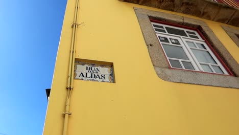 Marcador-Distintivo-En-La-Calle-Rua-Das-Aldas-En-Porto,-Junto-A-Una-Fachada-Amarilla