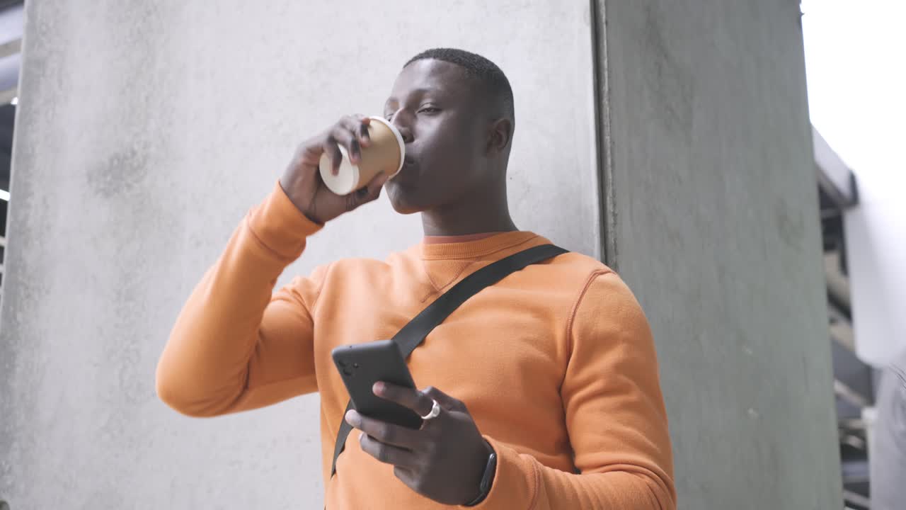 Passing stranger blocking view African American man sipping coffee scrolling messages on smartphone