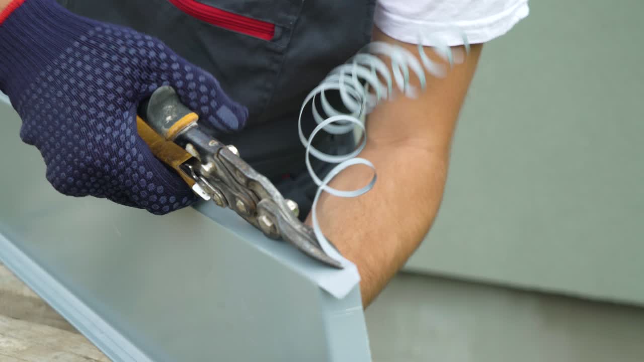 manos del trabajador con guantes de protección preparando el alféizar de la ventana de pvc cortando metal con tijeras de primer plano