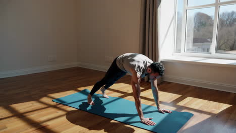 man performing exercises on a yoga mat indoors