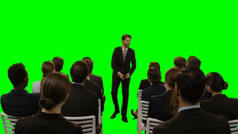 Businessman-using-futuristic-digital-screen-while-giving-presentation-to-colleagues