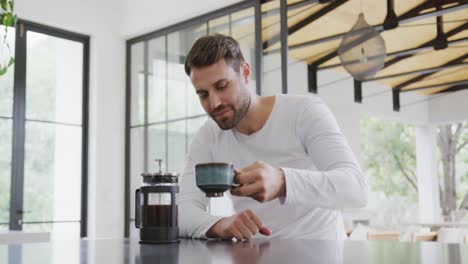 Man-drinking-coffee-at-dining-table-in-a-comfortable-home-4k