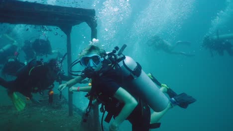 group of scuba divers exploring an underwater structure
