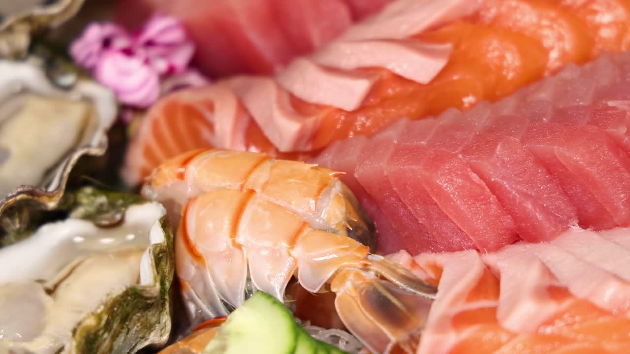 A close-up view of fresh sushi, shrimp, oysters, and cucumber slices artfully arranged.