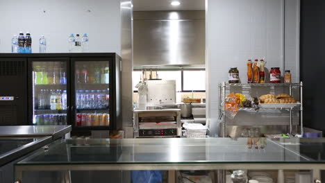 female head chef walking through commercial kitchen.