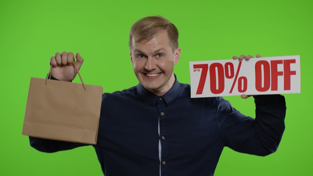 hombre feliz mostrando bolsas de compras y hasta un 70 por ciento de descuento en las inscripciones. buenos descuentos de vacaciones