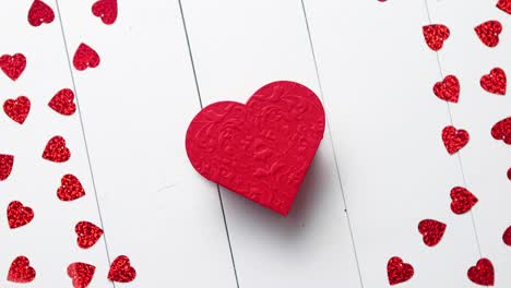 composición del día de vlentine lentejuelas en forma de corazón colocadas sobre una mesa de madera blanca