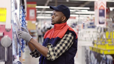 salesman standing in household hypermarket, arranging products