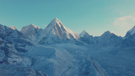 Drone view of Everest Base Camp trek in Khumbu, Nepal. Morning snowfall reveals Mount Pumori, Lobuche, and Nuptse glowing under clear blue skies as sunlight and sunrays reflect stunning Himalayas