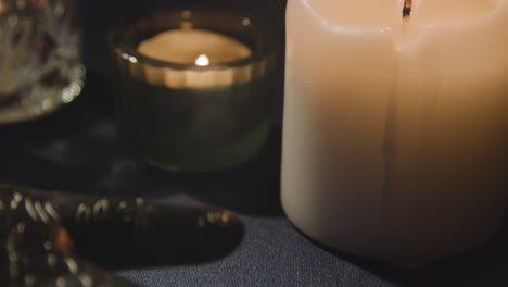 close up of model of hand used in palm reading surrounded by candles and crystals 1