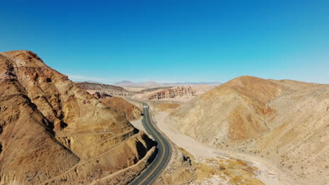 a picturesque highway through a rocky canyon in a desert landscape - sliding aerial view