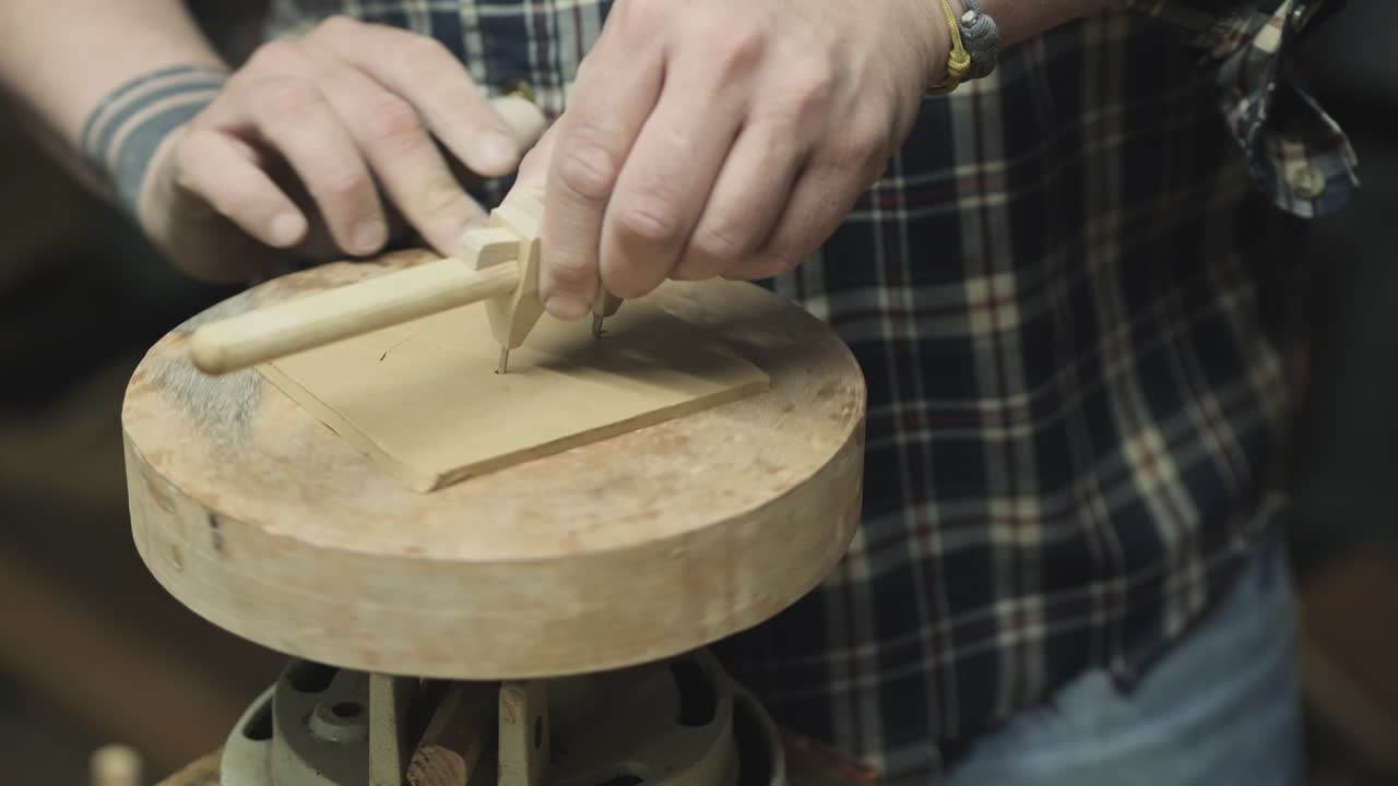 гончар разрезает круг из глины с помощью компаса