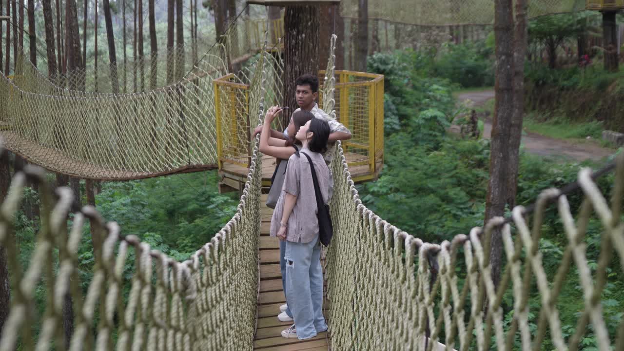 Asian Friends Taking Selfie on Forest Rope Bridge in Indonesia