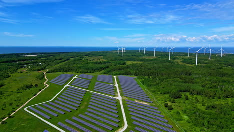 Renewable-energy-park-with-photovoltaic-and-windmills-in-green-landscape,-drone