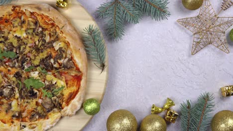 flat lay of pizza spinning 360 degree rotation on wooden salver, christmas decorations around.