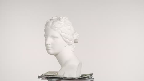 ancient bust on a pile of money