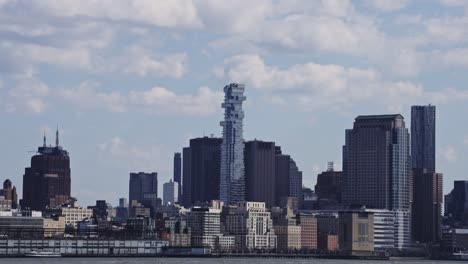 a striking view of manhattan’s skyline featuring the uniquely stacked residential tower, contrasted against classic city buildings and the waterfront