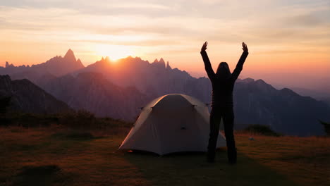 person meditating or stretching outdoors at sunrise/sunset with mountain view