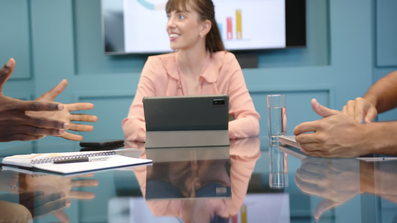 Meeting in office, woman using tablet and smiling, diverse colleagues discussing work