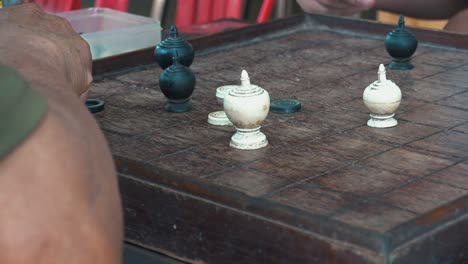 close shot of two asian men playing chess outside