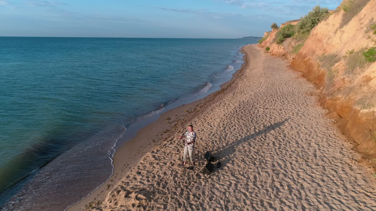 Man singing on the beach. Young man singing while standing on the beach