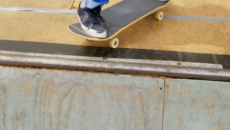 Close-up-of-young-man-doing-skateboard-trick-on-skateboard-ramp-at-skateboard-court-4k