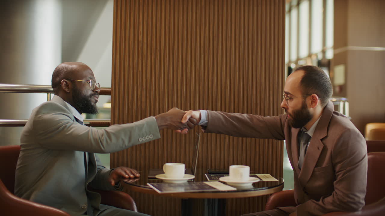 Partner commerciali che siglano un accordo con una stretta di mano durante un incontro al caffè