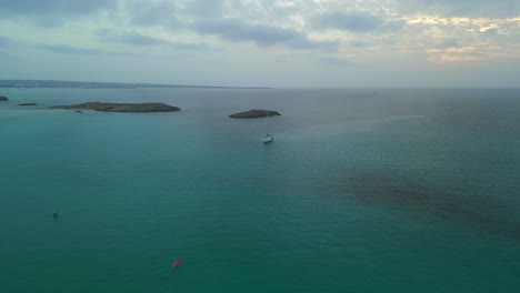 velero solitario al atardecer en la laguna azul