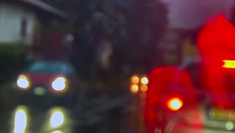 Nahaufnahme-Von-Depressivem-Schlechtem-Wetter-Mit-Regen-Und-Graupel,-Der-Auf-Beschlagener-Windschutzscheibe-Herunterrutscht,-Und-Verschwommenen-Lichtern-Des-Autoverkehrs-Im-Hintergrund