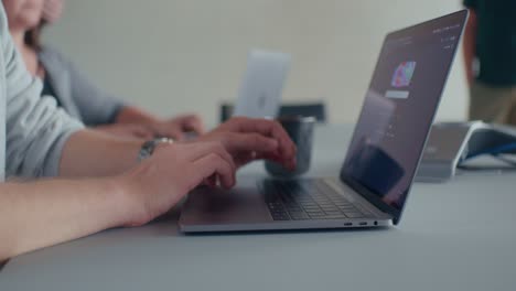 compañeros de equipo escribiendo en las computadoras portátiles en una oficina