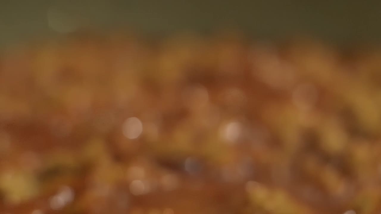 Bolognese tomato and meat sauce reveal while cooking traditionally.