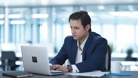 stressed indian corporate employee working on laptop