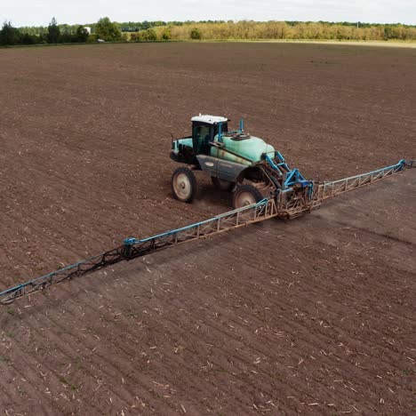 tractor spraying field with fertilizer