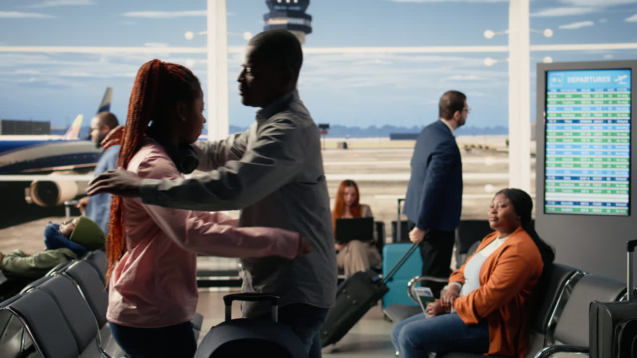 Teenager traveling alone, father hugging as goodbye, airport terminal lounge