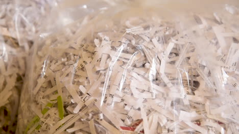 close up pan over a bag of shredded paper waiting to be recycled