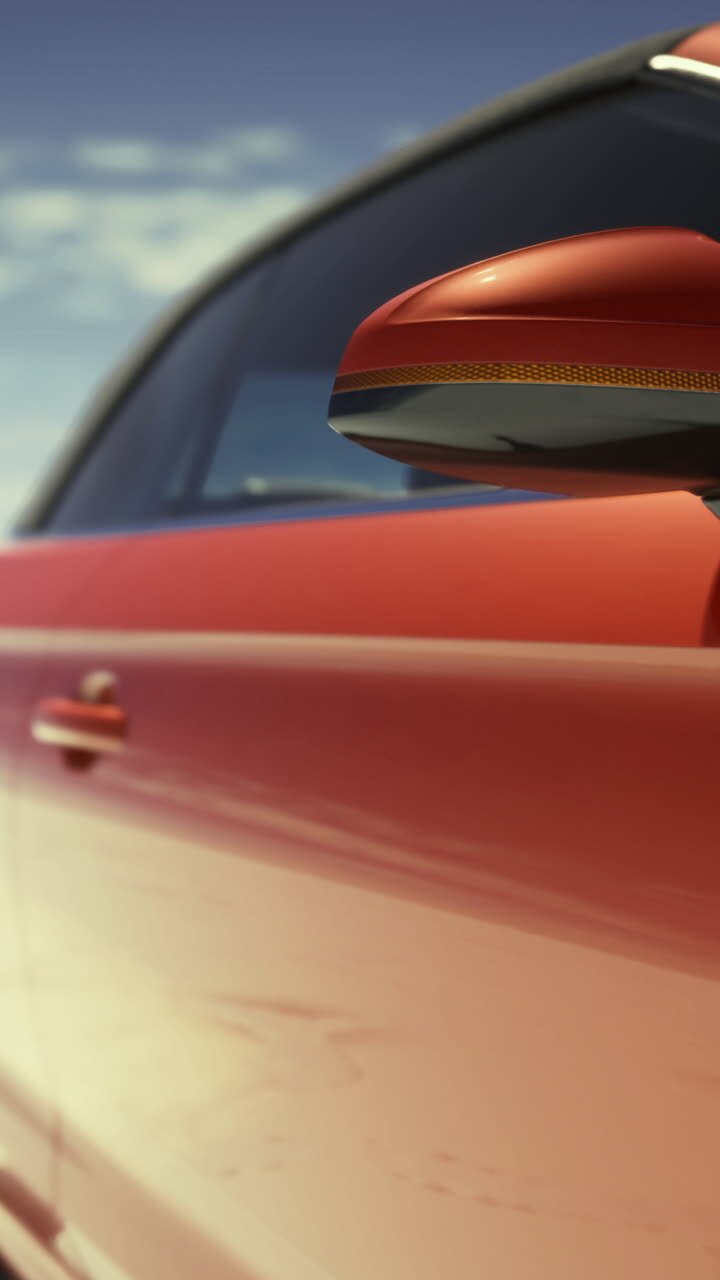Auto sportiva rossa moderna parcheggiata su un'ampia distesa salina sotto un cielo azzurro e limpido.