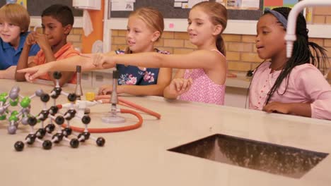 escolares estudiando el modelo molecular en el laboratorio