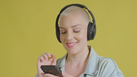 female caucasian model listening to music on headphones studio portrait 07