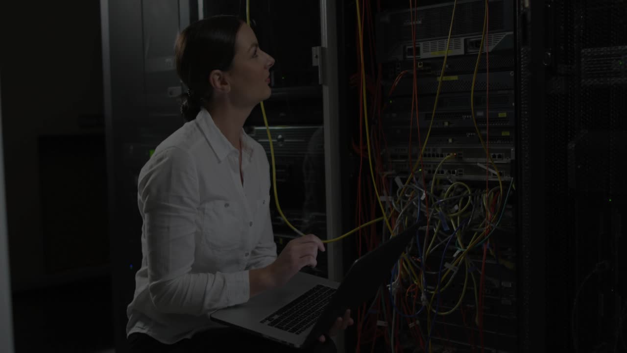 IT tech tracing yellow cable rack, causing red lock growing, settling over patch panel with laptop