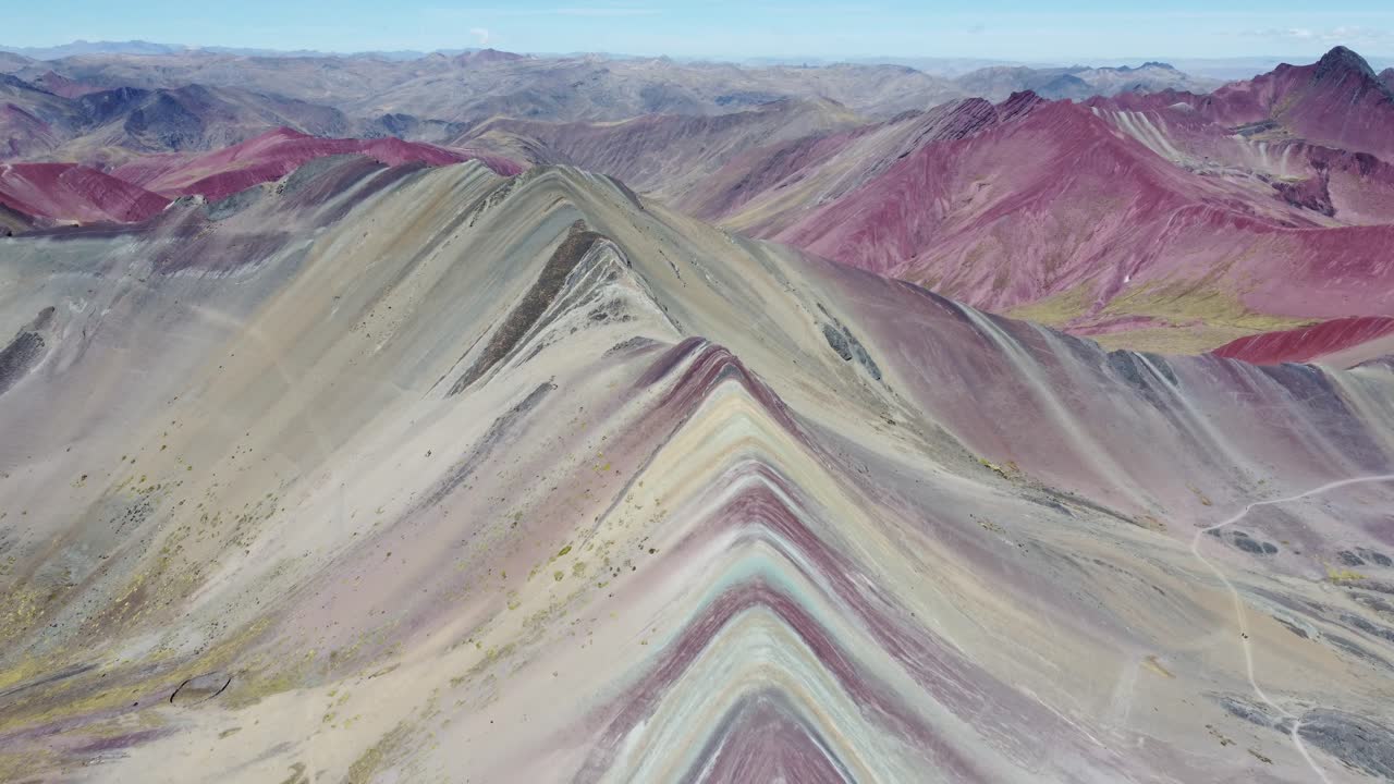 Expansive aerial the contrast of Vinicunca colorful slopes against the Andes
