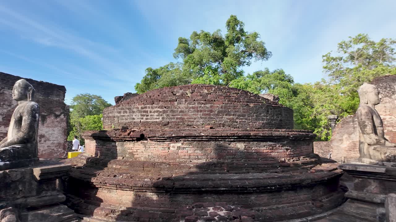 Buddha statues and Stupa inside Polonnaruwa Vatadage, showcasing ancient architecture from the Kingdom of Polonnaruwa in Sri Lanka. Slow Motion, Pan Right