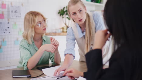 three women brainstorm new ideas during business meeting